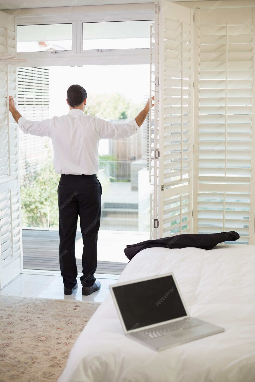 businessman-looking-through-window-hotel-bedroom_13339-171614